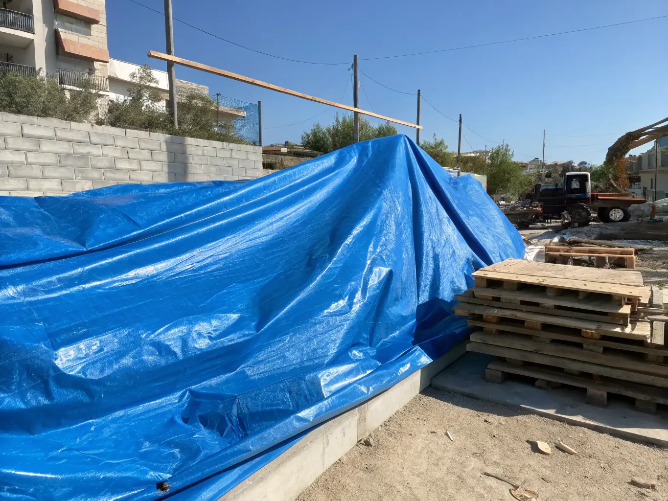 A high-resolution image displaying various types of tarpaulins (HDPE & LDPE) neatly stacked, highlighting their durability and weather resistance. The setting should be an outdoor environment, demonstrating their use in protecting goods from the elements.