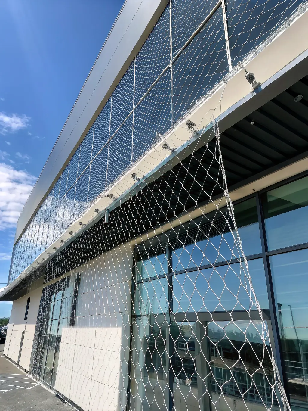 A close-up shot of a tightly woven nylon bird net, showcasing its fine mesh and durability, installed on a residential balcony to prevent birds from entering.