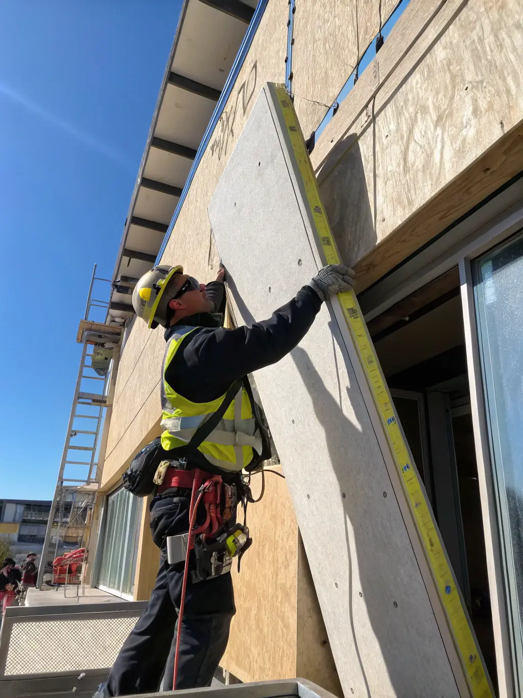 A worker safely installing invisible grills on a high-rise building, demonstrating the safety aspect of preventing birds from nesting in dangerous areas.